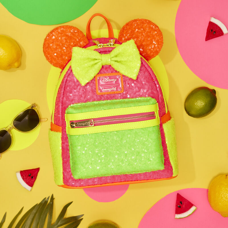 Loungefly Minnie Mouse Exclusive Color Block Neon Sequin Mini Backpack against a bright yellow background surrounded by lemons, limes, and watermelon slices. 